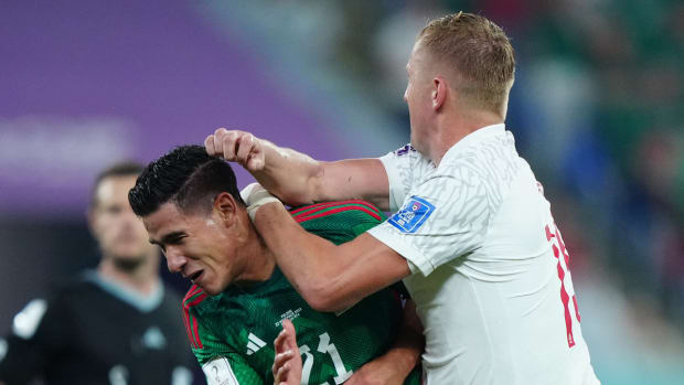 Poland’s Kamil Glik collides with Mexico forward Uriel Antuna during 2022 World Cup match in Qatar.